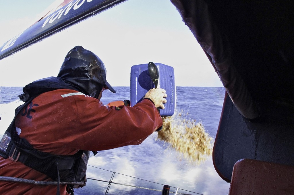 Rob Salthouse gets rid of lunch left overs onboard CAMPER with Emirates Team New Zealand during leg 1 of the Volvo Ocean Race 2011-12, from Alicante, Spain to Cape Town, South Africa. (Credit: Hamish Hooper/CAMPER ETNZ/Volvo Ocean Race) © Hamish Hooper/Camper ETNZ/Volvo Ocean Race